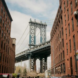 Manhattan Bridge framed by red brick buildings in DUMBO, Brooklyn, NYC, a popular tourist spot.