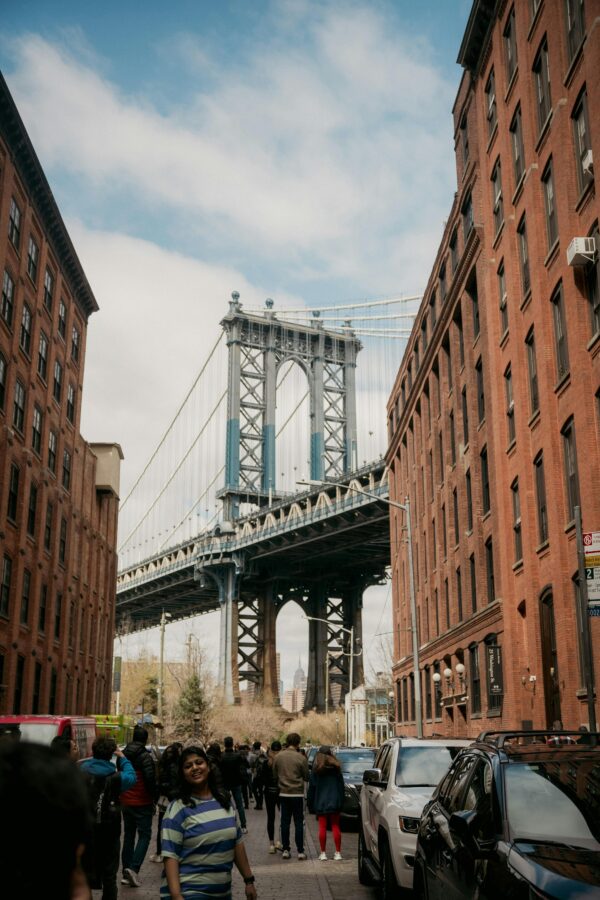 Manhattan Bridge framed by red brick buildings in DUMBO, Brooklyn, NYC, a popular tourist spot.