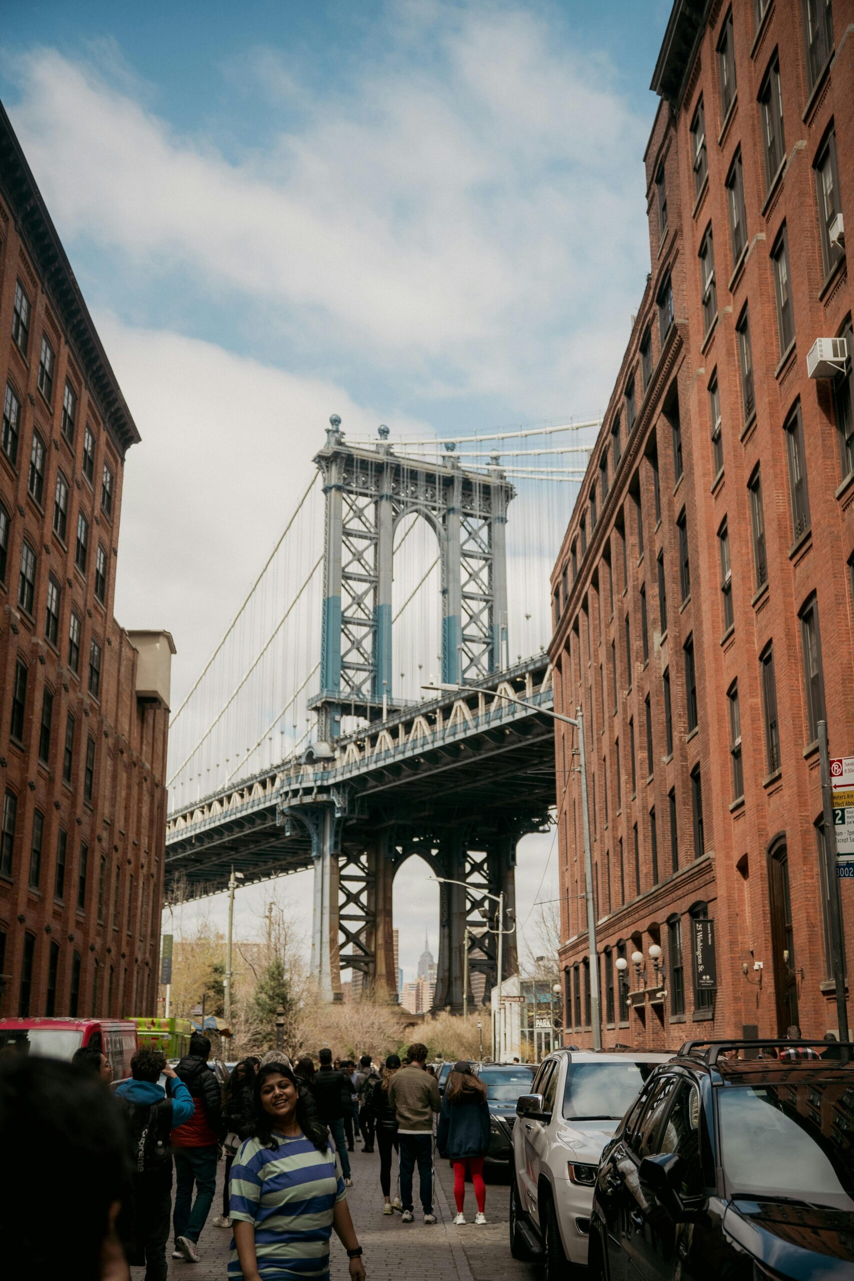 Manhattan Bridge framed by red brick buildings in DUMBO, Brooklyn, NYC, a popular tourist spot.