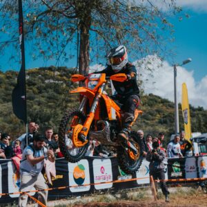 Action-packed capture of a motorcyclist executing a jump during an outdoor enduro race.