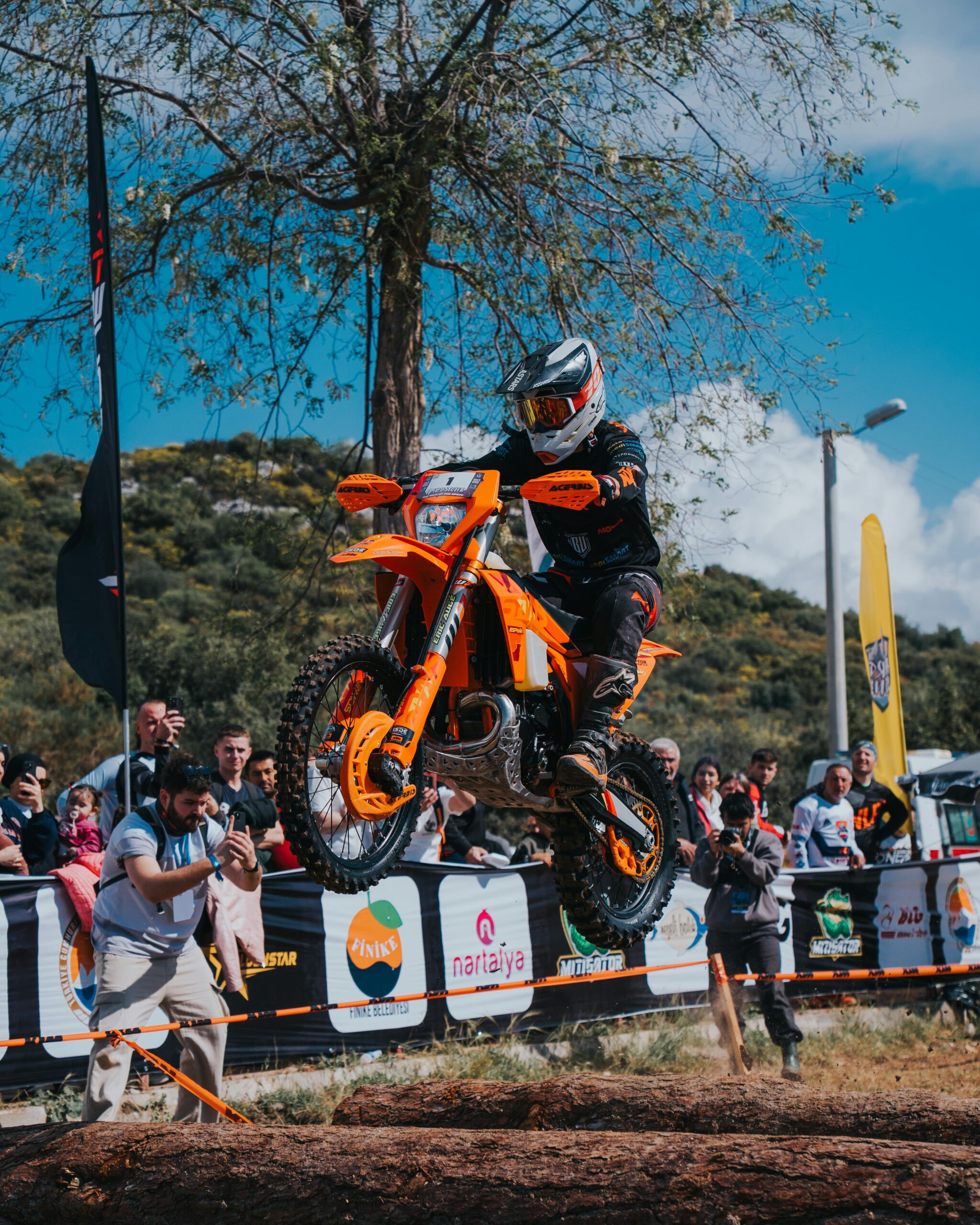 Action-packed capture of a motorcyclist executing a jump during an outdoor enduro race.